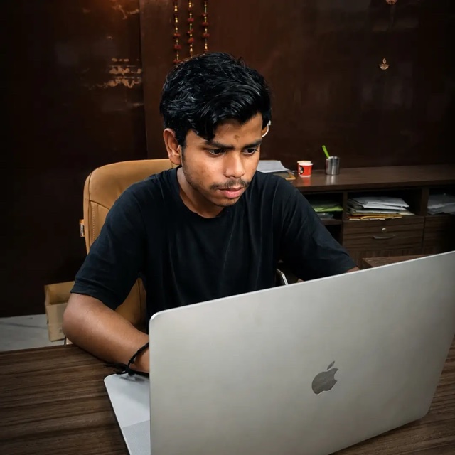 Vansh Kashyap, a web developer in New Delhi, working on a MacBook at his office desk